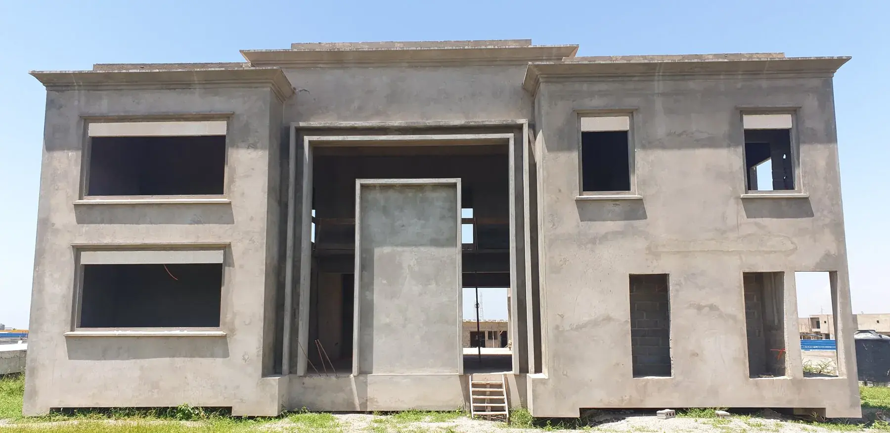 Façade en béton brut d'une grande villa à deux niveaux