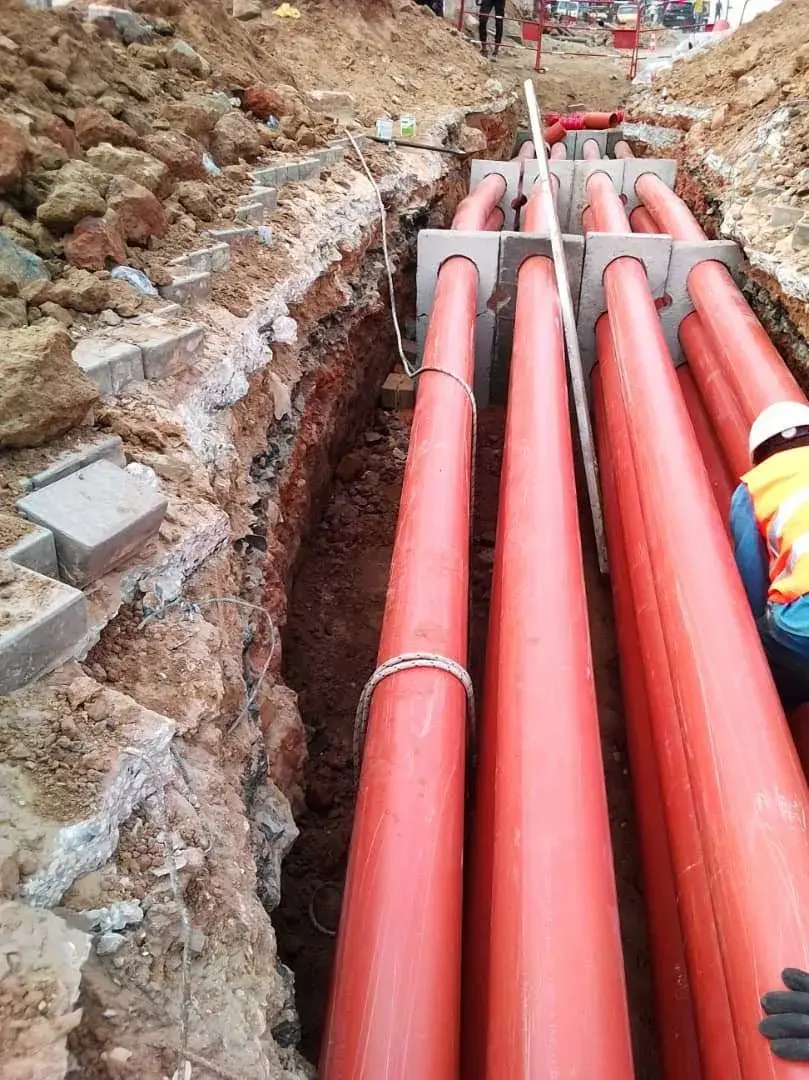 Fourreaux rouges posés en fond de fouille sur des supports béton